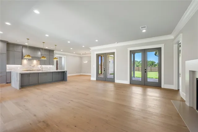 a kitchen with stainless steel appliances granite countertop a sink a stove and a wooden floors