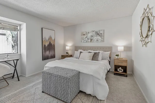 a spacious bedroom with a bed and a chandelier