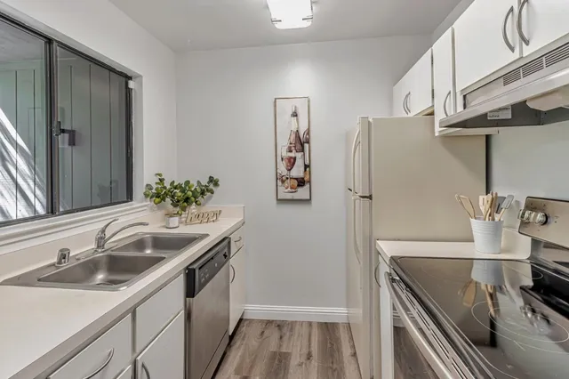 a kitchen with stainless steel appliances a sink and a refrigerator
