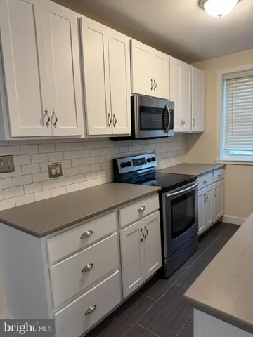 a kitchen with stainless steel appliances granite countertop white cabinets a sink and dishwasher