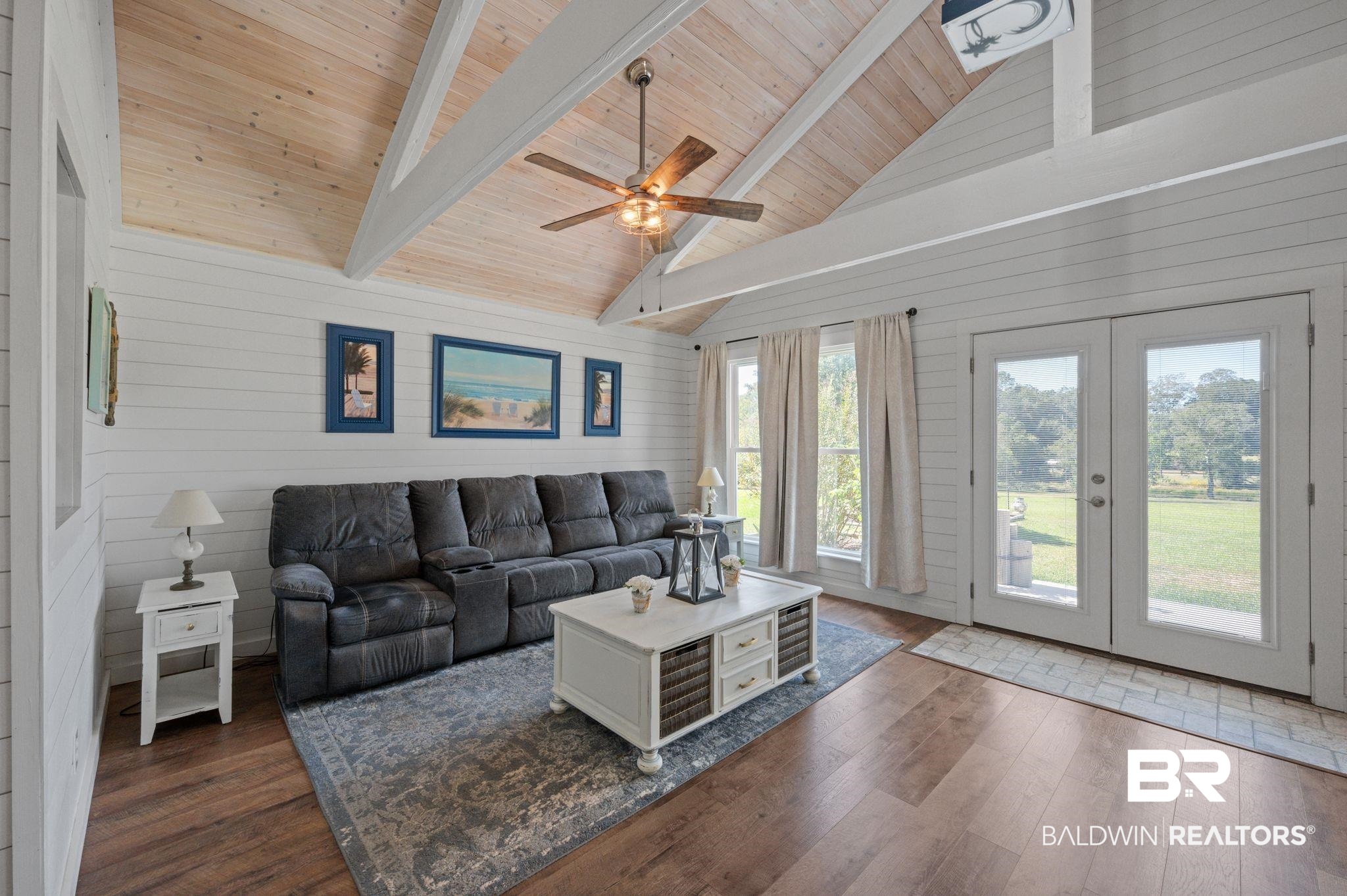 20037 County Road 33 Fairhope, AL 36532 - Photo 10 of 79 Living room featuring wood walls, a healthy amount of sunlight, and dark hardwood / wood-style flooring