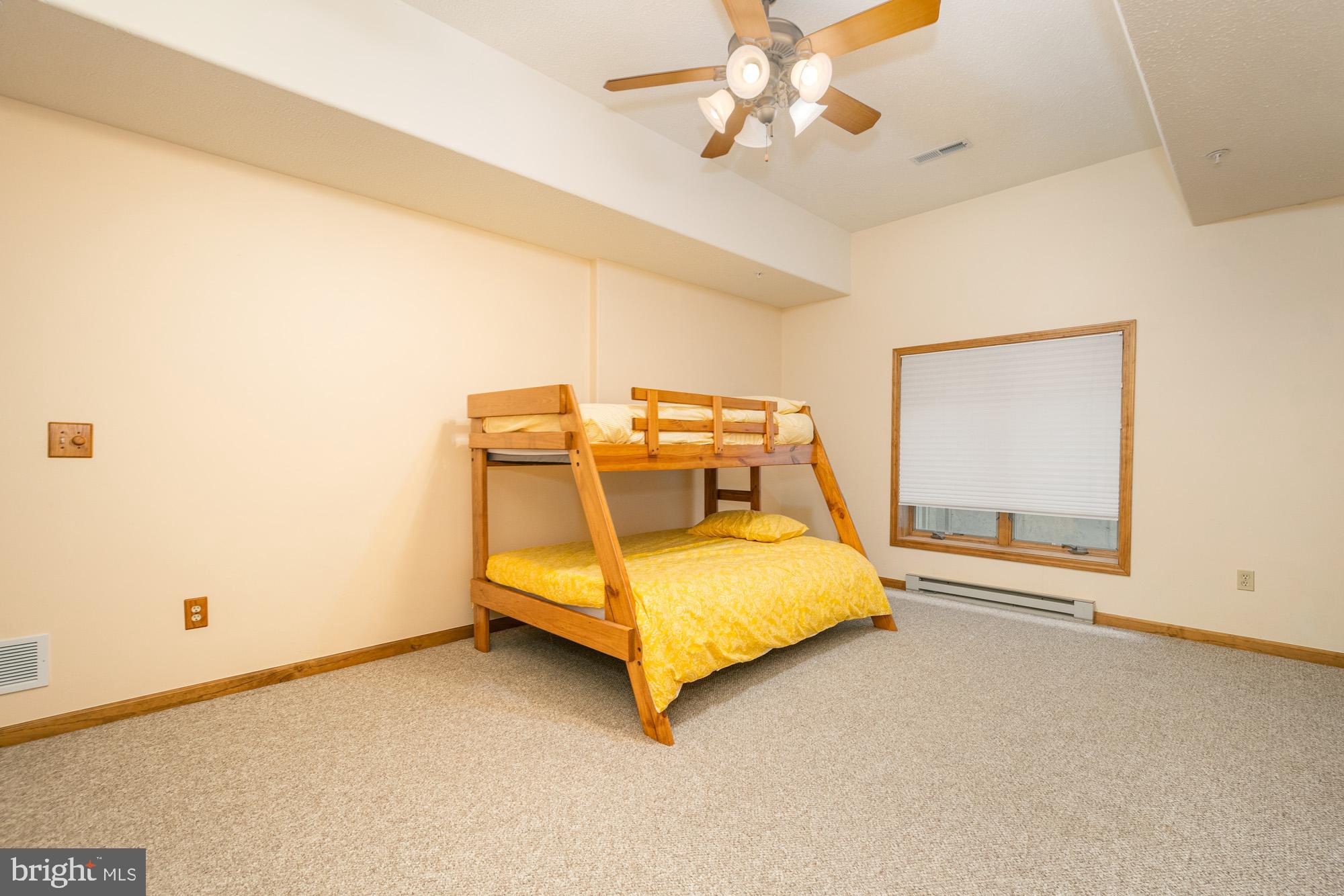 750 Wisp Mountain Road, Unit B McHenry, MD 21541 - Photo 19 of 49 a bedroom with a bed and a chandelier