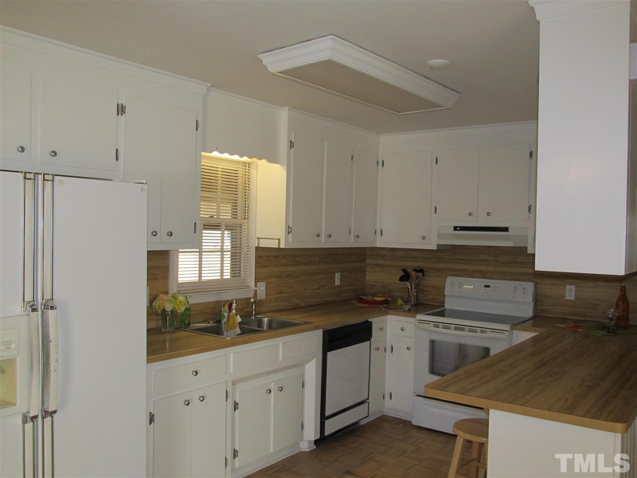 512 Old Stage Road North Coats, NC 27521 - Photo 8 of 18 a kitchen with white cabinets and appliances