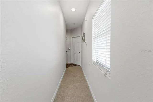 a view of a hallway with wooden floor and a window
