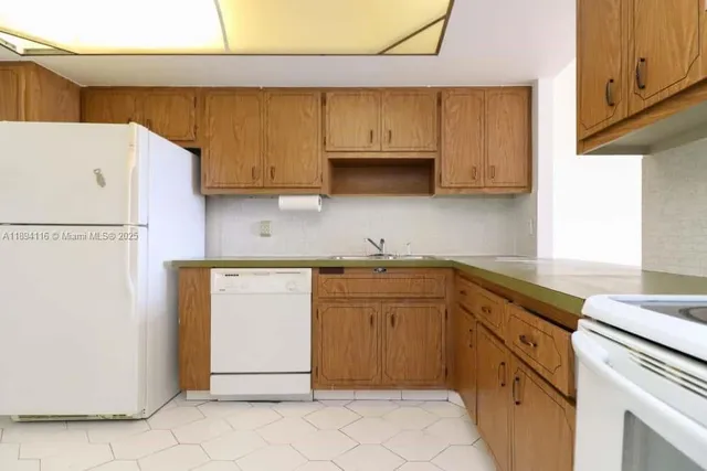 a kitchen with stainless steel appliances granite countertop a sink a stove a refrigerator a microwave and cabinets