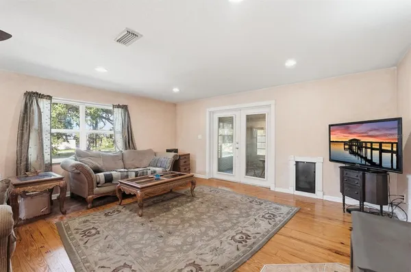 a dining room with furniture a chandelier and wooden floor