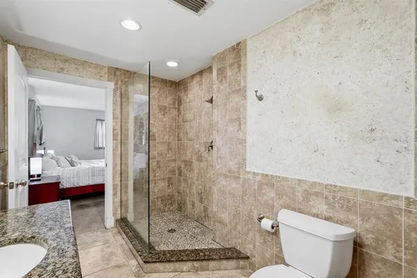a bathroom with a granite countertop toilet a sink and a mirror