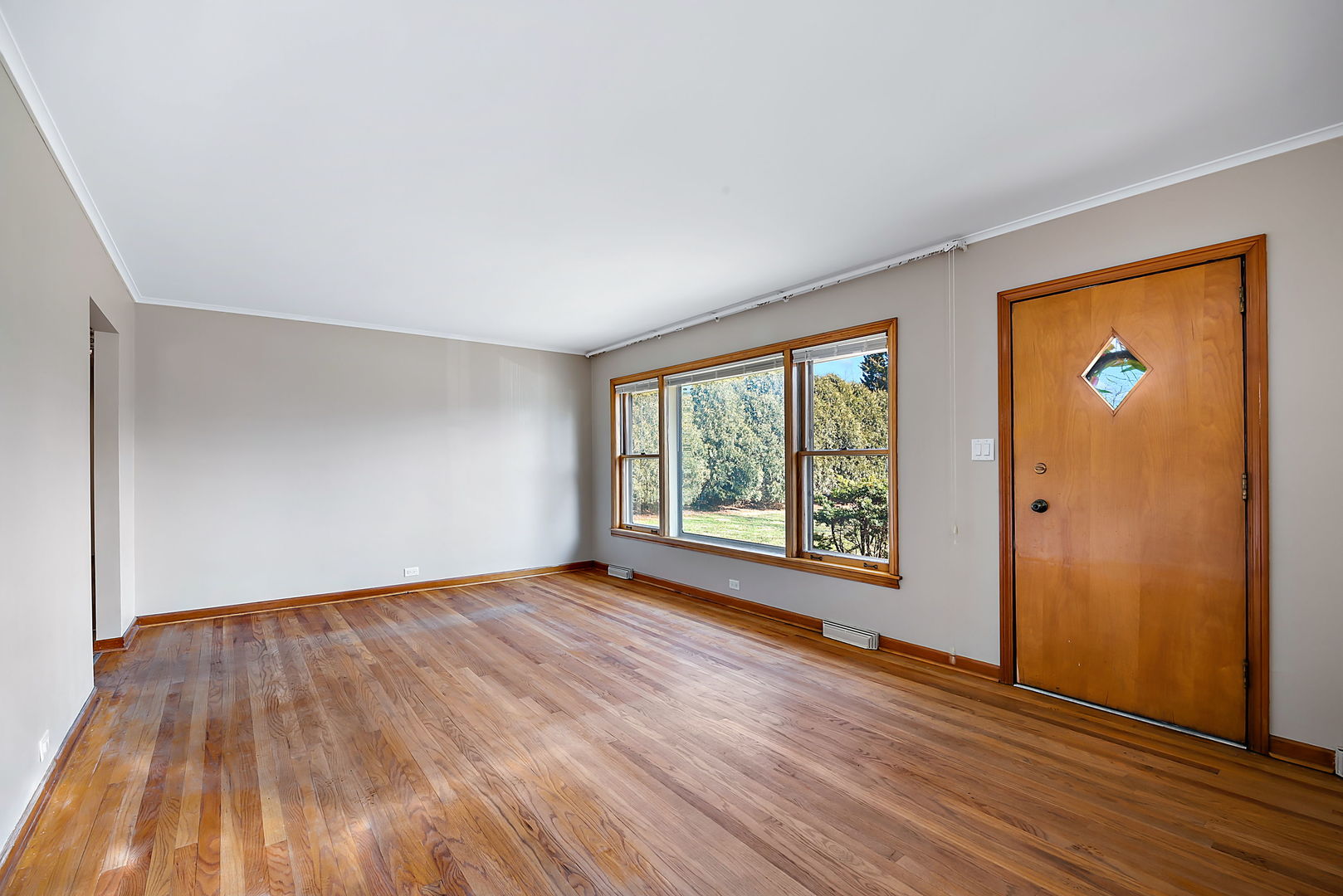 256 North Jackson Road Clarendon Hills, IL 60514 - Photo 4 of 30 a view of an empty room with wooden floor and a window