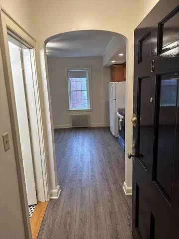 a view of hallway with a wooden floor and a window