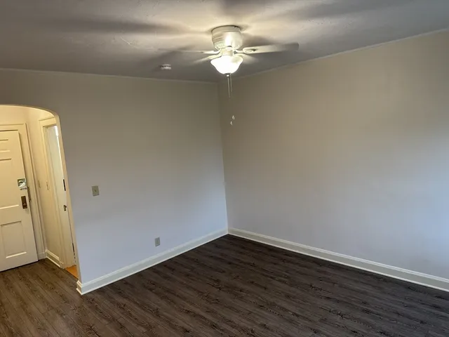 a view of a room with wooden floor and a ceiling fan