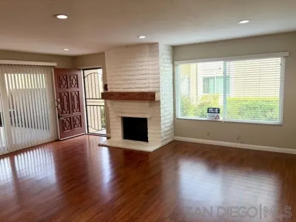 an empty room with wooden floor and fireplace