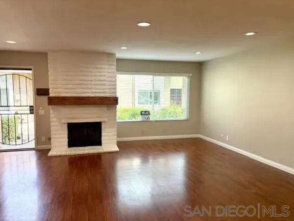 a view of a livingroom with wooden floor and a fireplace