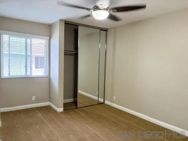 an empty room with closet and windows