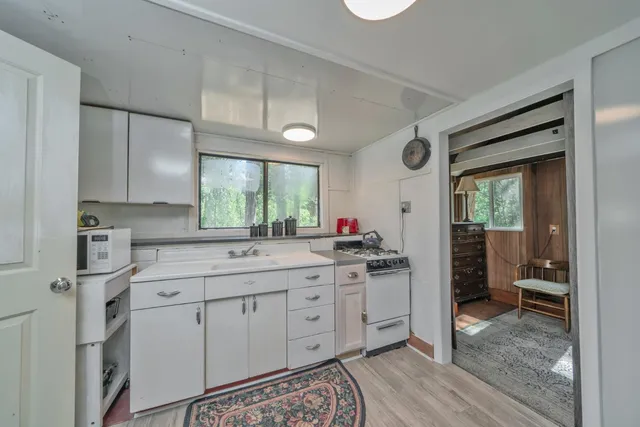 a kitchen with a sink cabinets and wooden floor