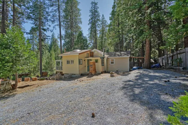 a view of a house with a large tree and a yard