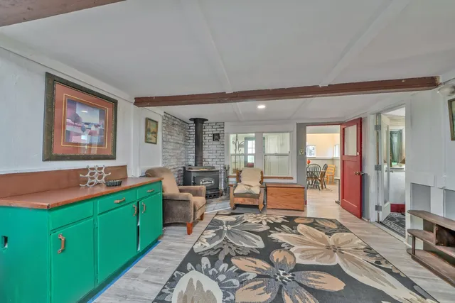 a large living room with stainless steel appliances kitchen island granite countertop furniture a rug and a large window