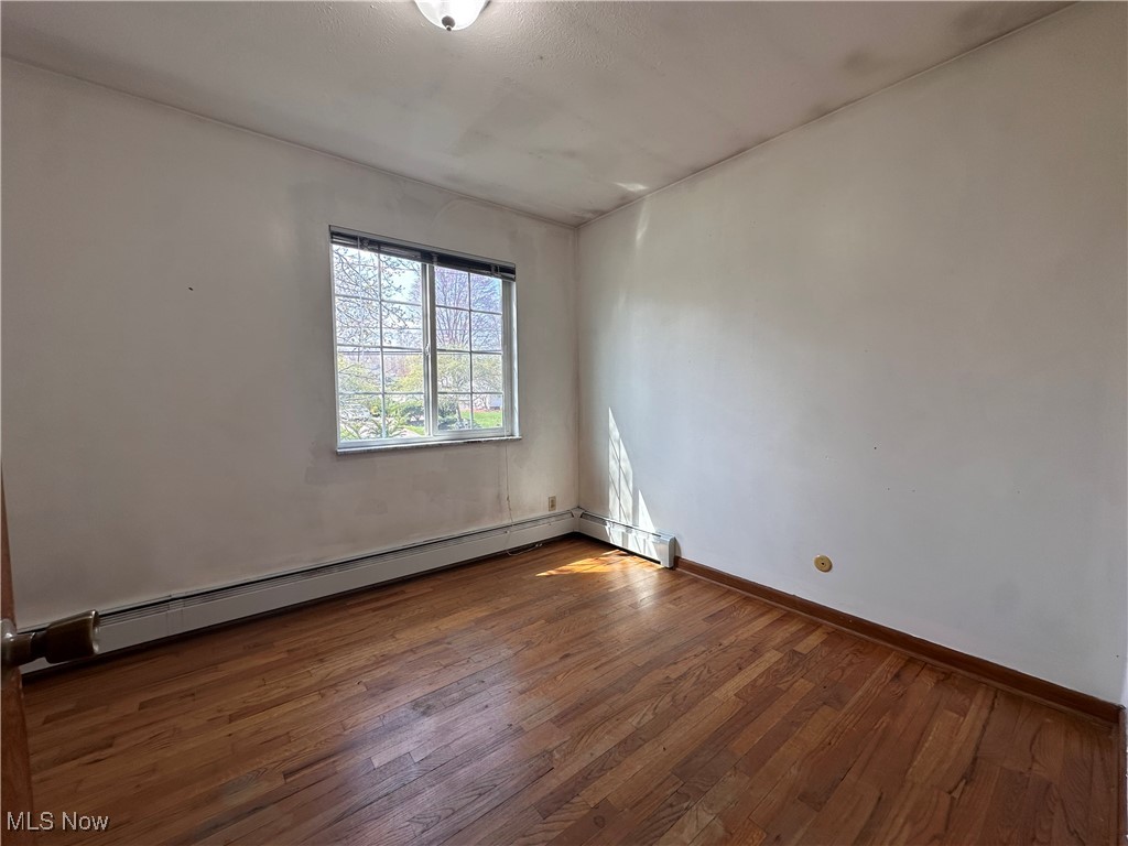 2829 Shellhart Road Barberton, OH 44203 - Photo 6 of 29 Upper level nfurnished room with dark wood finished floors, a baseboard radiator, and baseboards
