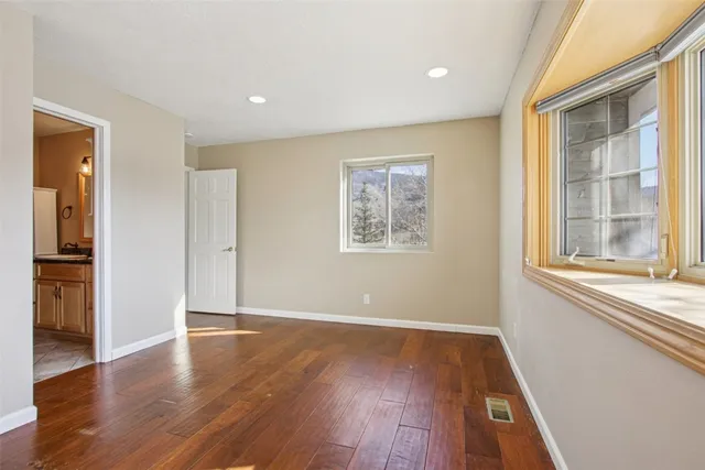 a view of empty room with wooden floor