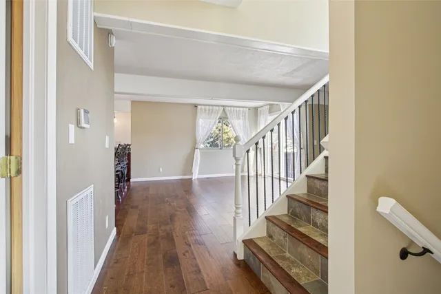 a view of a hallway with wooden floor and staircase