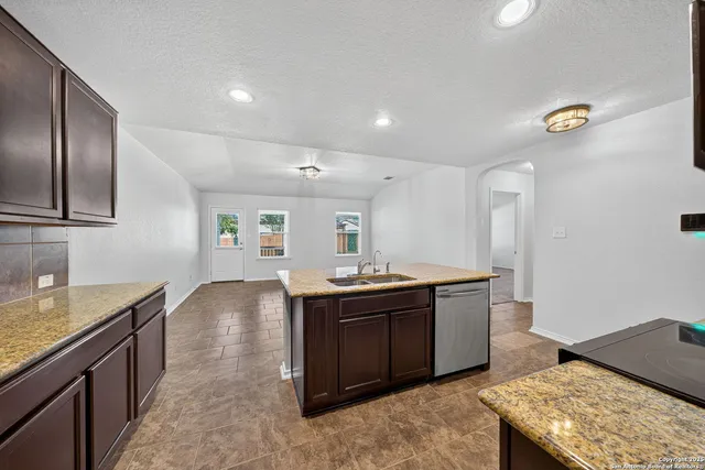 a kitchen with stainless steel appliances granite countertop a sink and stove top oven