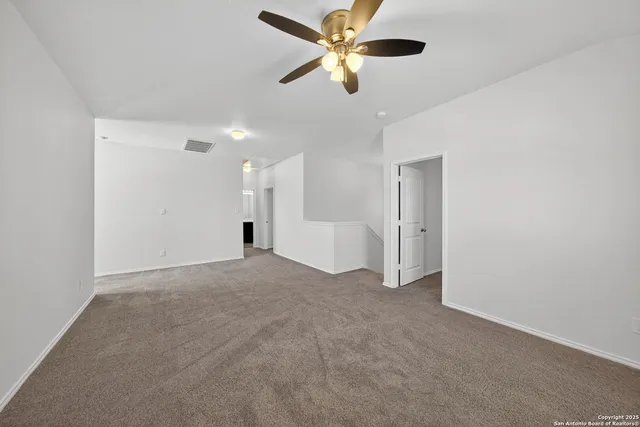 a view of a livingroom with a ceiling fan and window