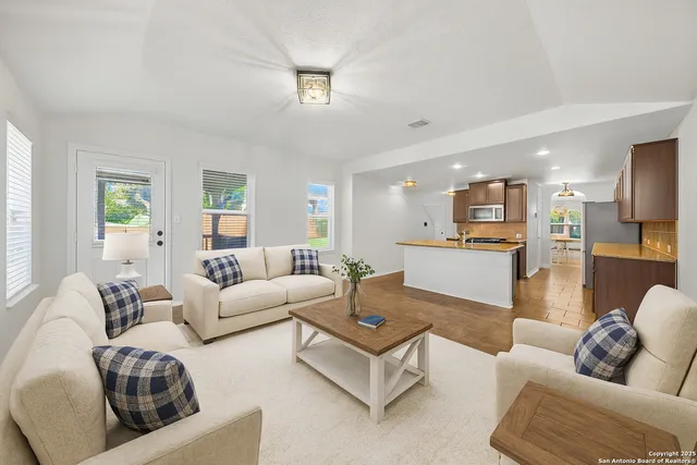 a living room with furniture kitchen and a table