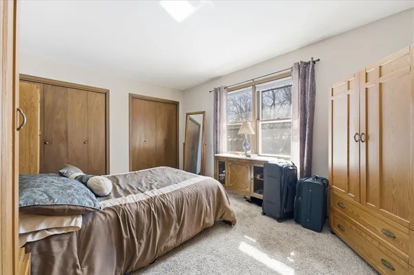 a bedroom with a bed closet and a large window