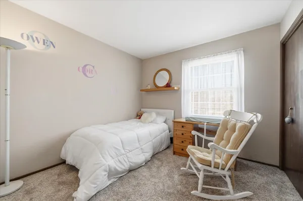 a bedroom with a bed and a chair