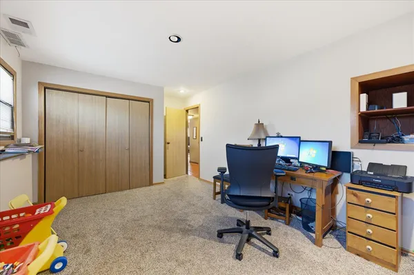 a view of a workspace with furniture and a window