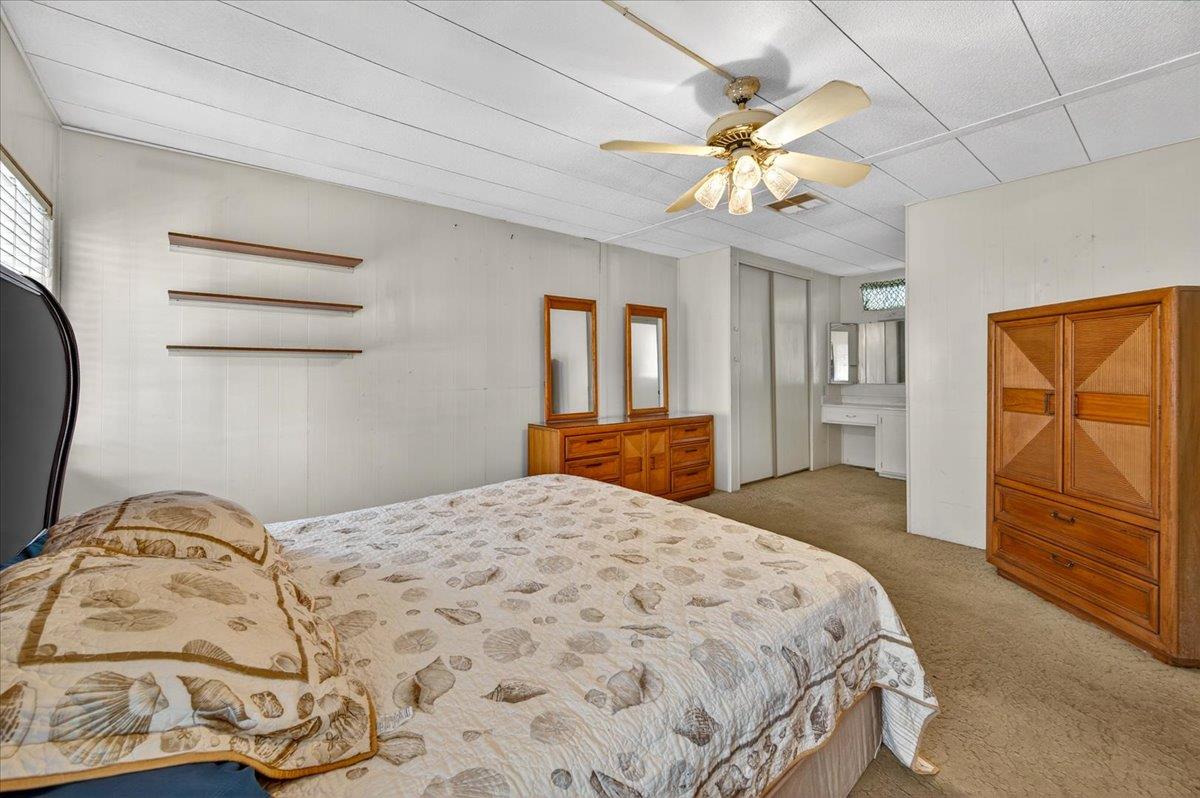 2706 West Ashlan Avenue, Unit 86 Fresno, CA 93705 - Photo 29 of 61 a bedroom with a bed and dresser with mirror