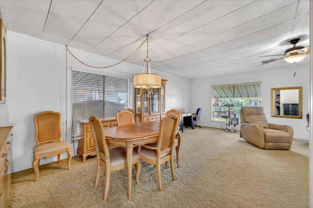 2706 West Ashlan Avenue, Unit 86 Fresno, CA 93705 - Photo 39 of 61 a dining room with furniture a chandelier and window