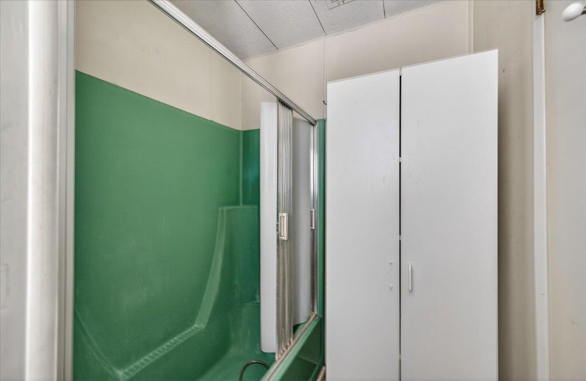 2706 West Ashlan Avenue, Unit 86 Fresno, CA 93705 - Photo 49 of 61 a bathroom with a green shower curtain and a sink