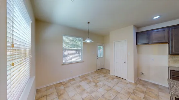 a view of an empty room with window and chandelier fan