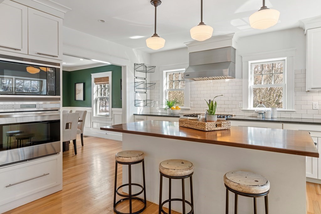 84 Moffat Road Newton, MA 02468 - Photo 16 of 39 a kitchen with stainless steel appliances granite countertop a kitchen island hardwood floor sink stove dining table and chairs