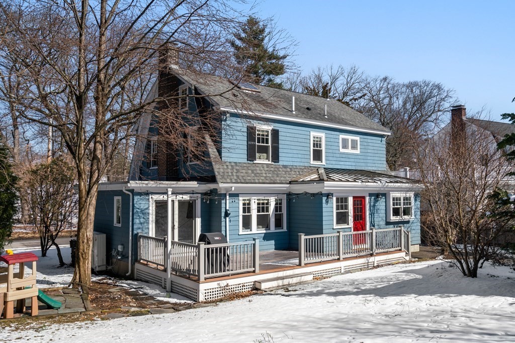 84 Moffat Road Newton, MA 02468 - Photo 37 of 39 a view of a white house with large windows and a table and chair