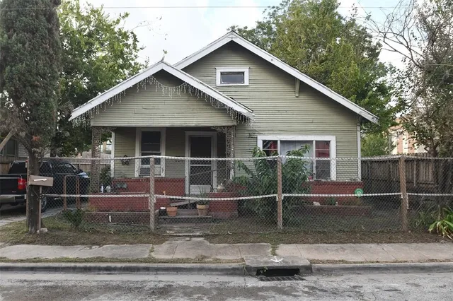 a view of a house with a yard and wooden fence