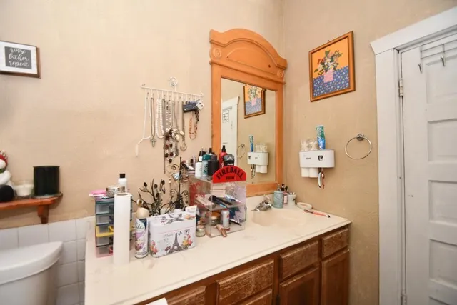 a bathroom with a sink vanity mirror and toilet