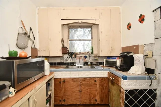 a kitchen with stainless steel appliances a stove a sink and a microwave