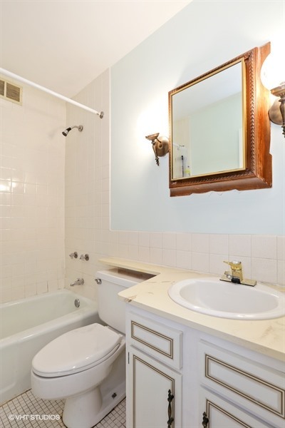 6171 North Sheridan Road, Unit 1107 Chicago, IL 60660 - Photo 11 of 18 a bathroom with a toilet a sink and mirror