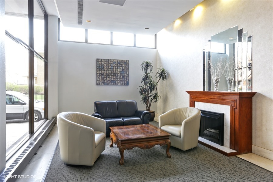 6171 North Sheridan Road, Unit 1107 Chicago, IL 60660 - Photo 3 of 18 a living room with furniture a large window and a fireplace