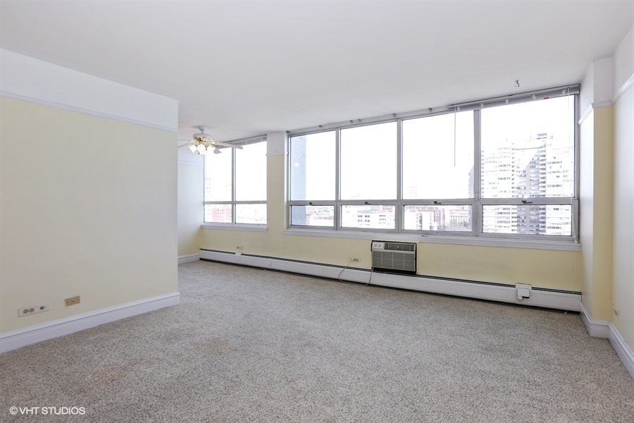 6171 North Sheridan Road, Unit 1107 Chicago, IL 60660 - Photo 4 of 18 an empty room with wooden floor and windows