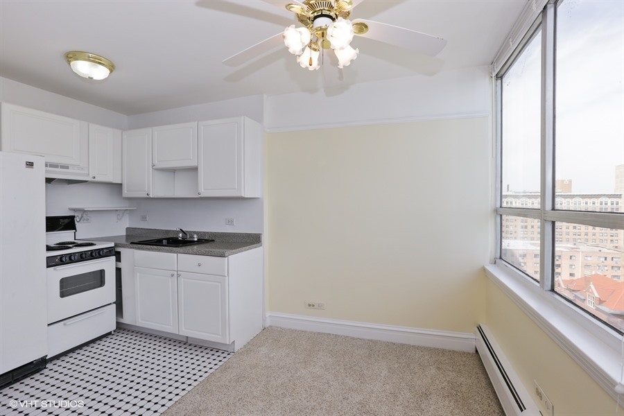6171 North Sheridan Road, Unit 1107 Chicago, IL 60660 - Photo 9 of 18 a kitchen with a stove a sink and a window