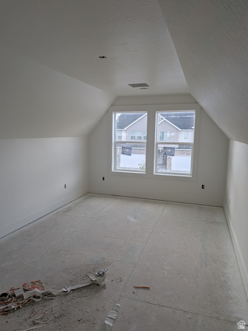 2771 West Aurora Avenue Mapleton, UT 84664 - Photo 23 of 39 Room featuring a sloped ceiling, two pane windows, light-colored walls, and a concrete subfloor