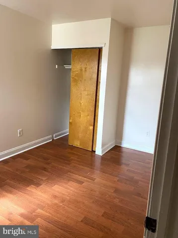 an empty room with wooden floor and closet