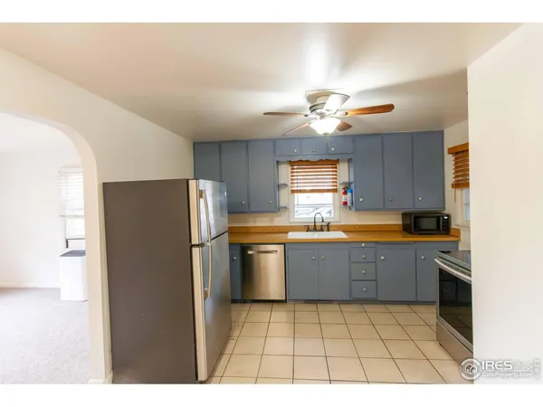 a kitchen with a refrigerator a sink dishwasher with a dining table and chairs
