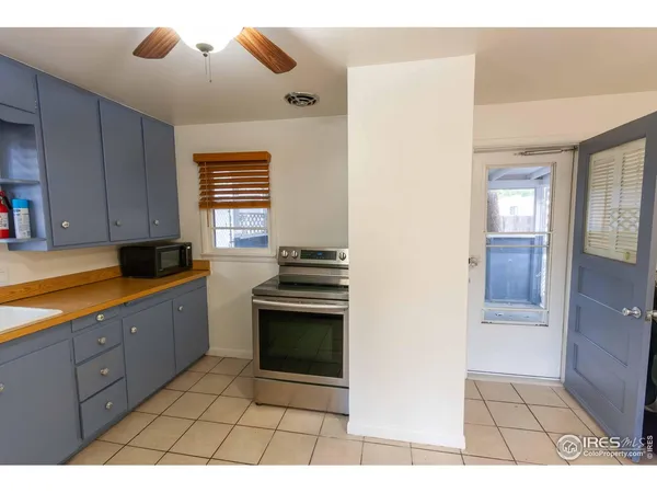 a kitchen with granite countertop a stove a sink and a refrigerator
