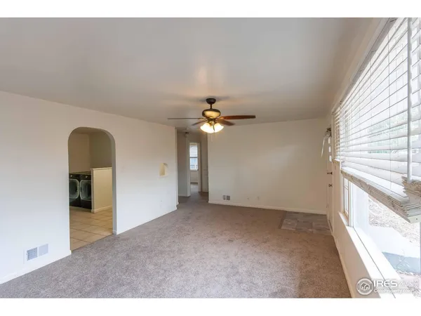 a view of a room with a ceiling fan and window