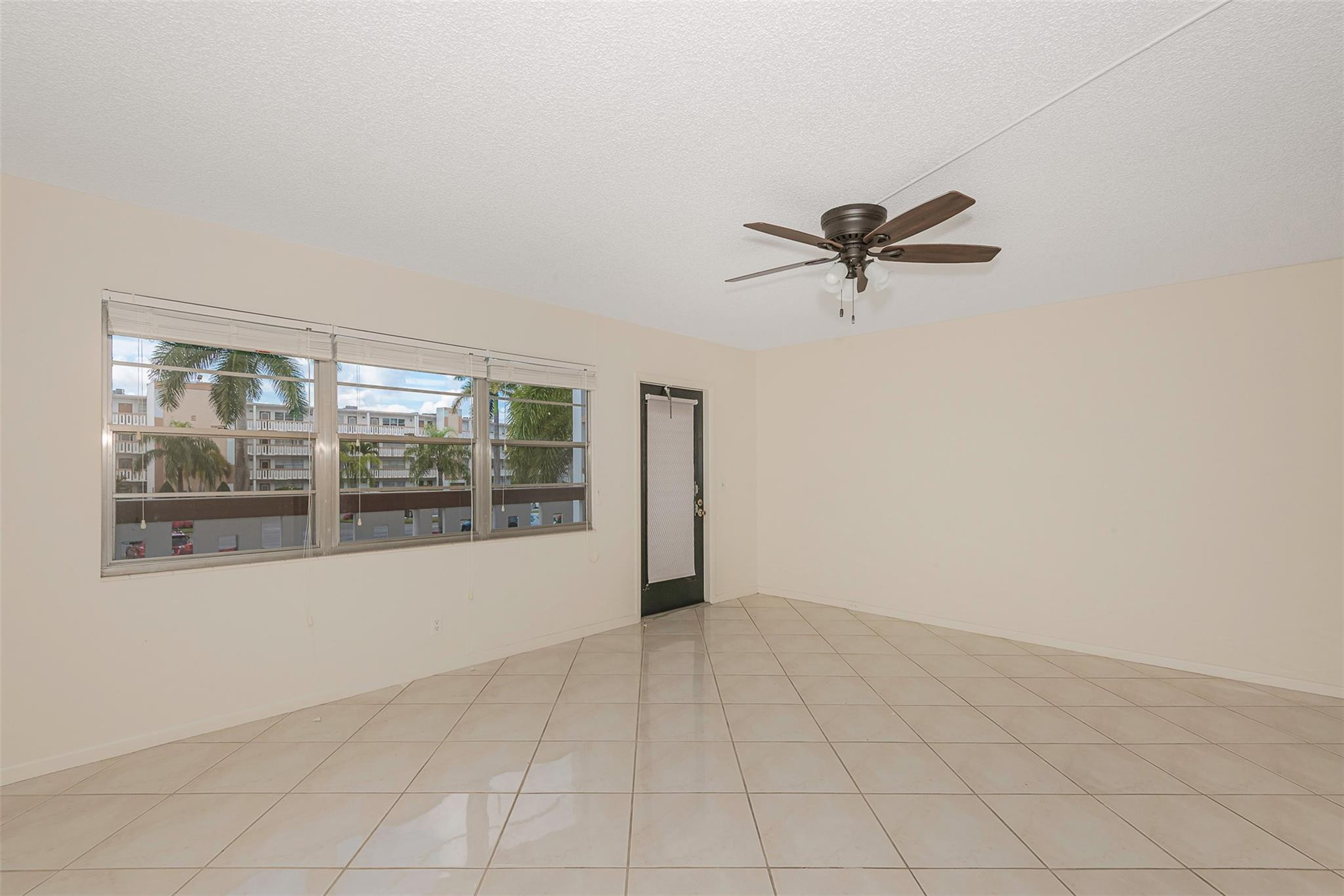 2009 Cornwall Drive, Unit 2009 Boca Raton, FL 33434 - Photo 12 of 23 an empty room with windows and chandelier fan