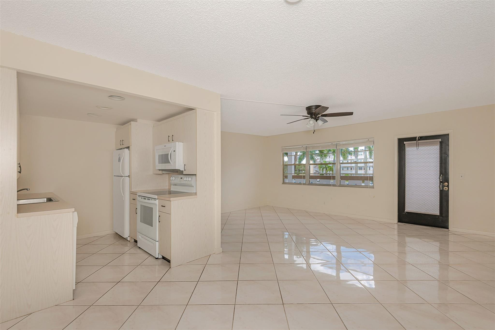 2009 Cornwall Drive, Unit 2009 Boca Raton, FL 33434 - Photo 13 of 23 a kitchen with white cabinets and window