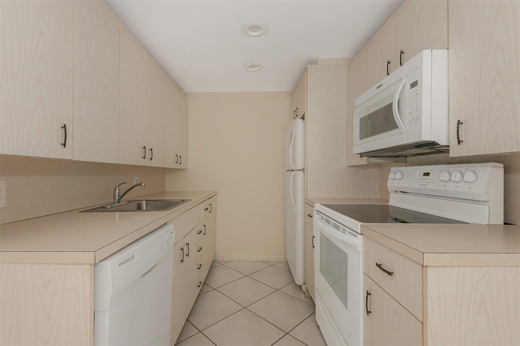2009 Cornwall Drive, Unit 2009 Boca Raton, FL 33434 - Photo 4 of 23 a kitchen with granite countertop white cabinets and white appliances